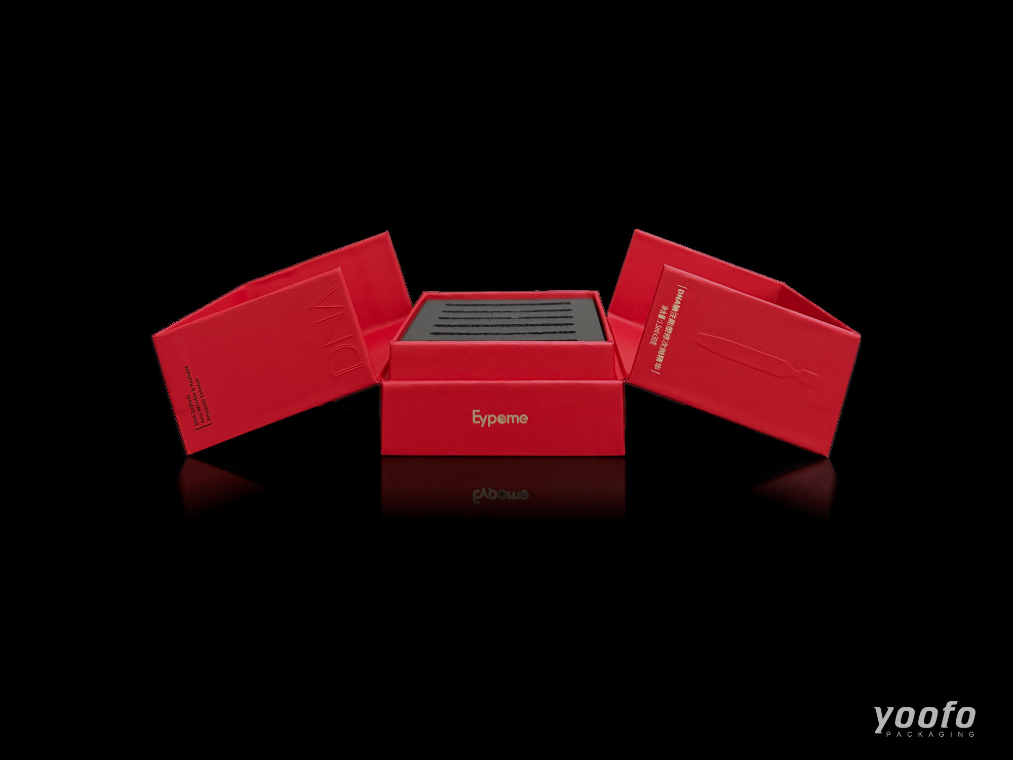 Red double-door cosmetic box opened to both sides, showing black EVA foam insert with ampoule slots